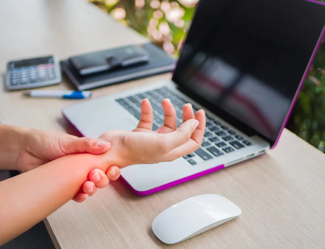 Closeup woman holding her wrist pain from using computer. Office syndrome hand pain by occupational disease. Jak najnowsze technologie wpływają na nasze ręce?
