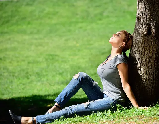 Woman enjoying the sun in the park Duży biust – zbędny balast dla kręgosłupa?