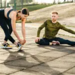 Sporty girl is stretching with her fit boyfriend in fitness outfit outdoors Ruch W Pandemii 515x313 1